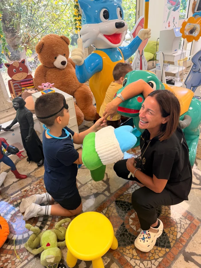 Azzurra e un bambino esplorano un modello con uno spazzolino grande